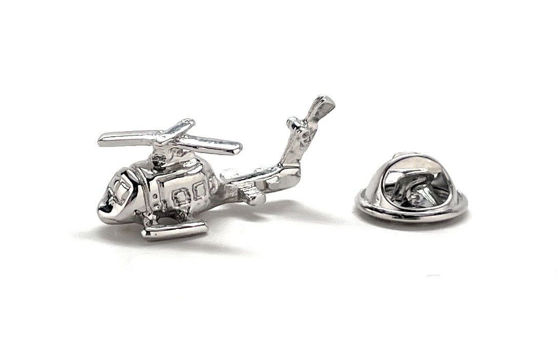 Silver helicopter-shaped lapel pin on a white background