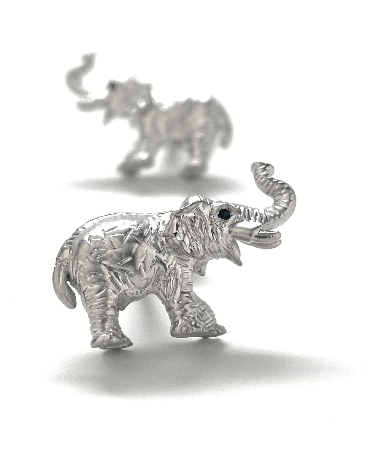 Silver elephant figurines on a white background