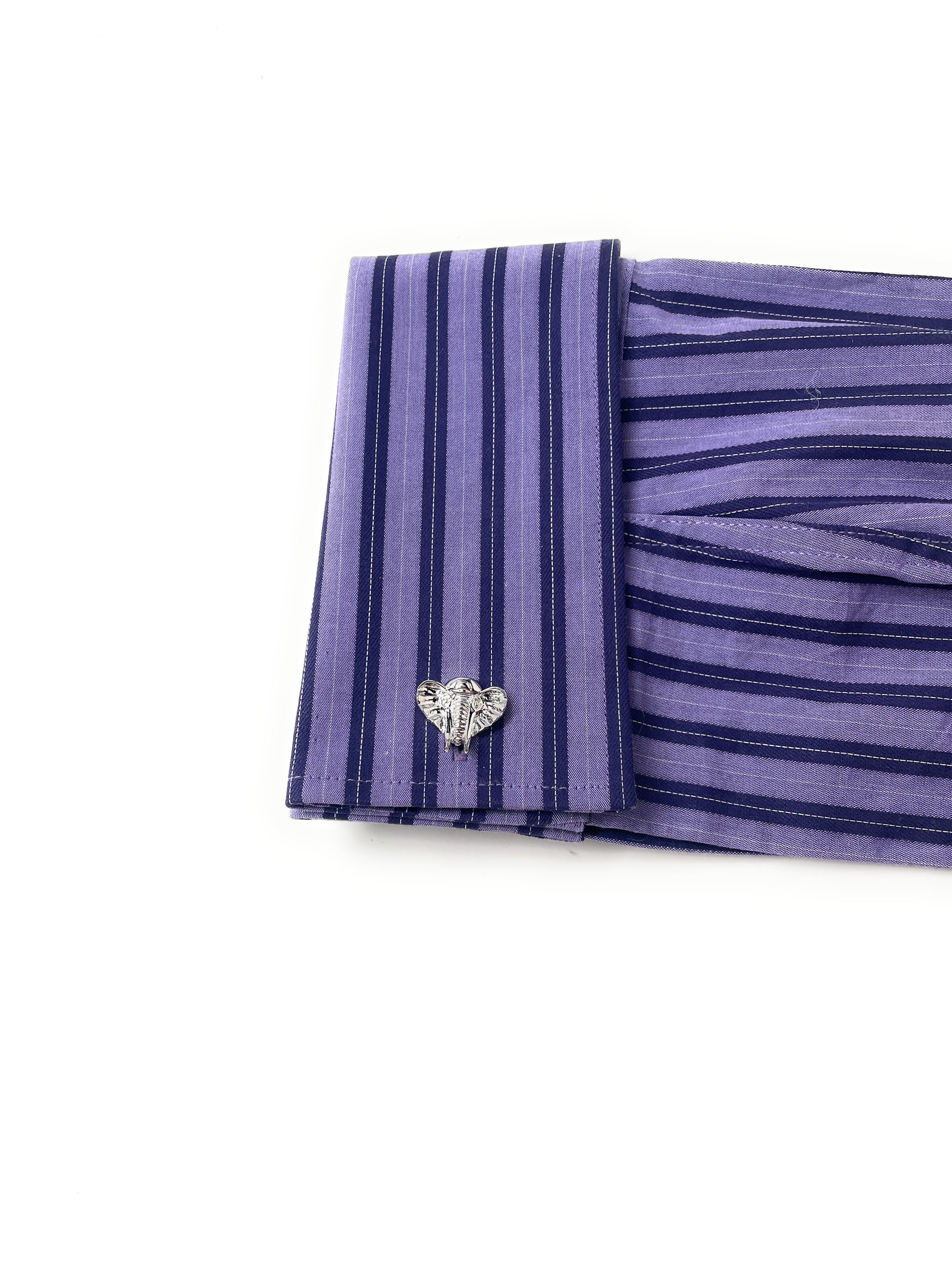 Purple striped fabric with a heart-shaped brooch on a white background