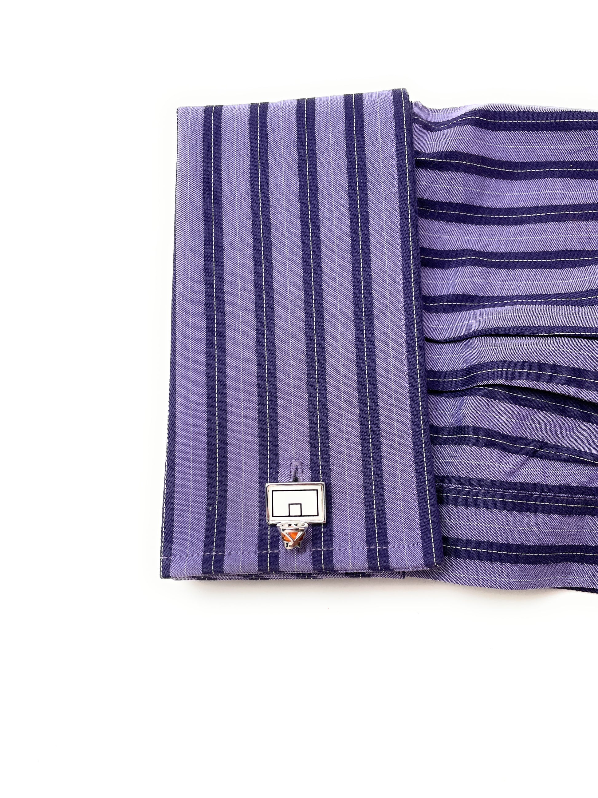 Purple striped fabric with a small basketball hoop pin on a white background