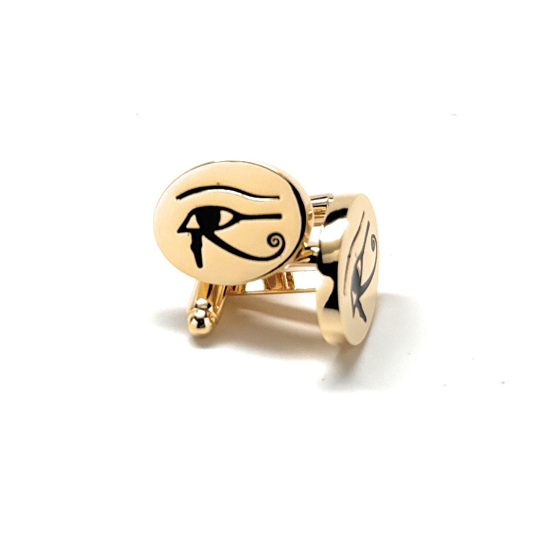 Gold cufflinks with an eye design on a white background