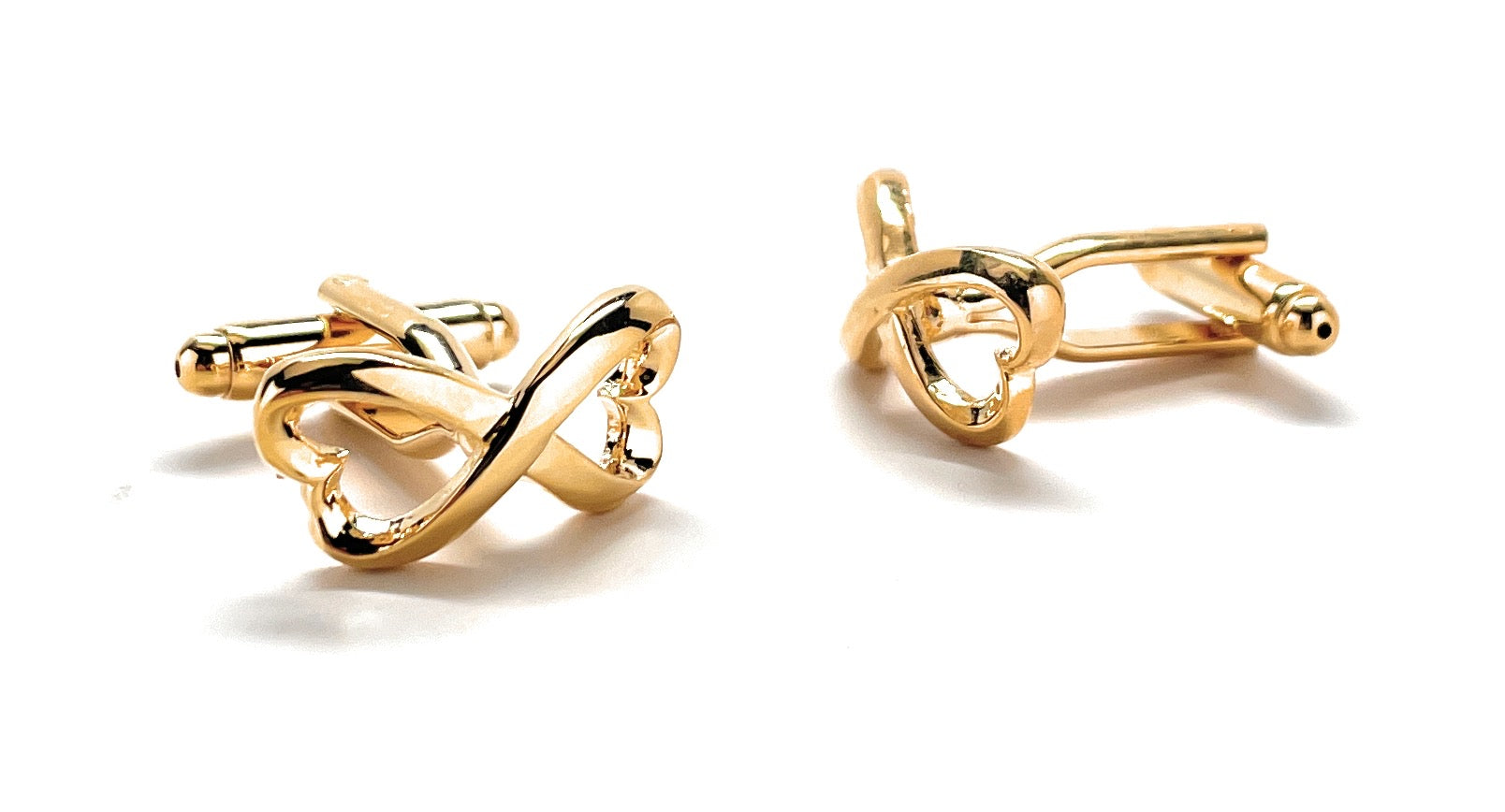 Gold cufflinks with intricate design on a white background