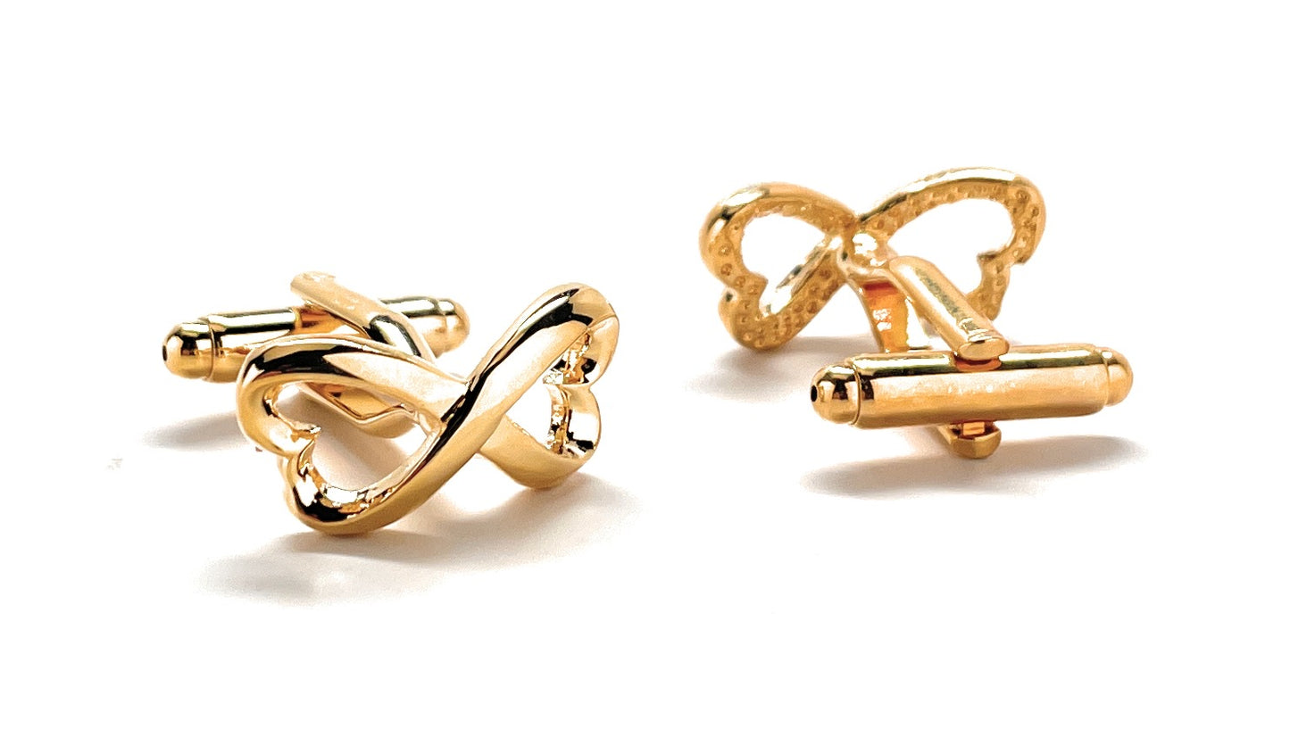 Gold bow-shaped cufflinks on a white background