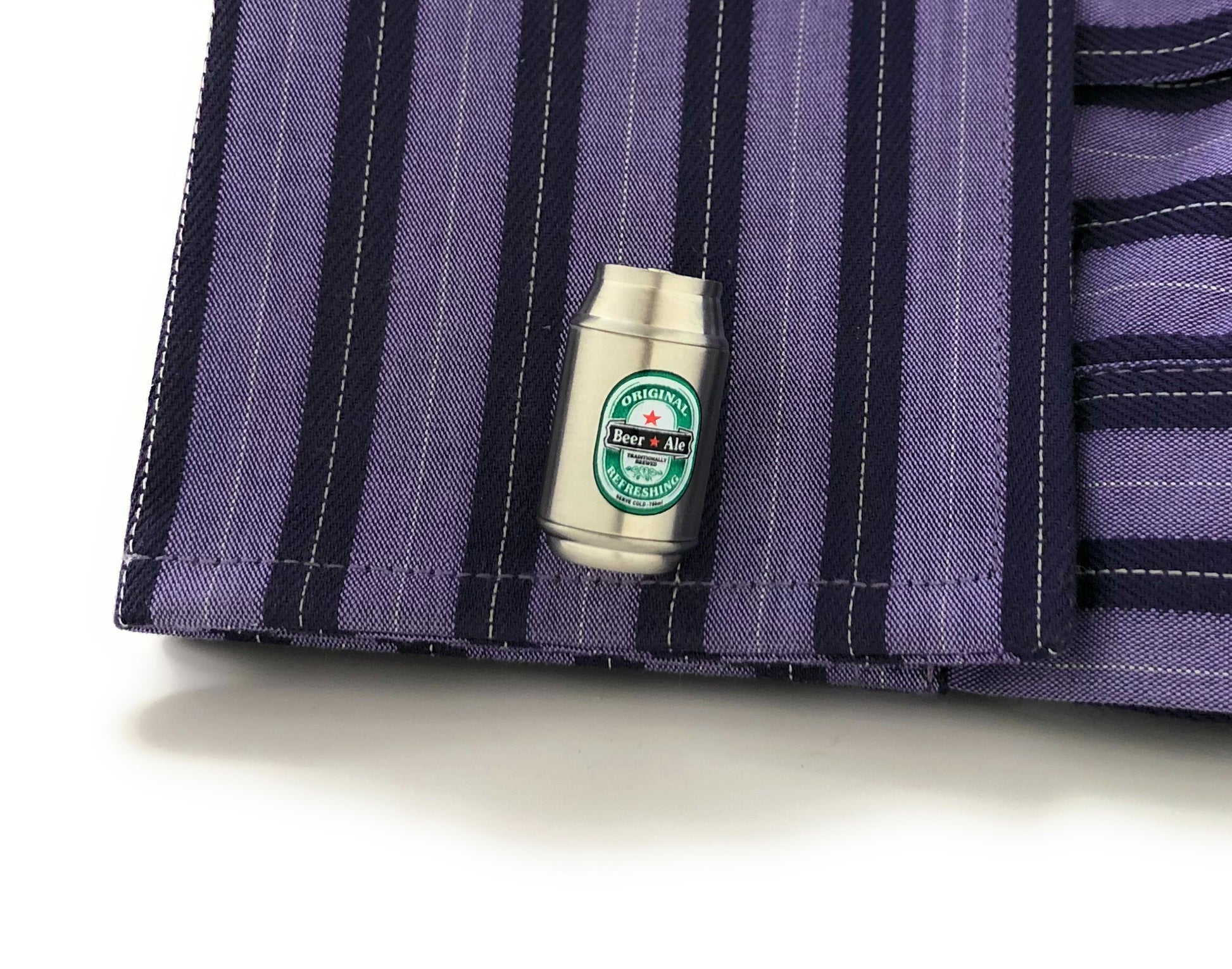 Small bottle with a label on a purple striped fabric background