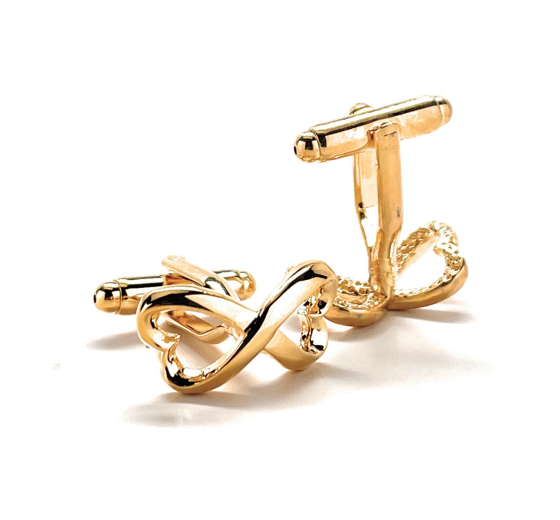 Gold cufflinks with an intricate design on a white background