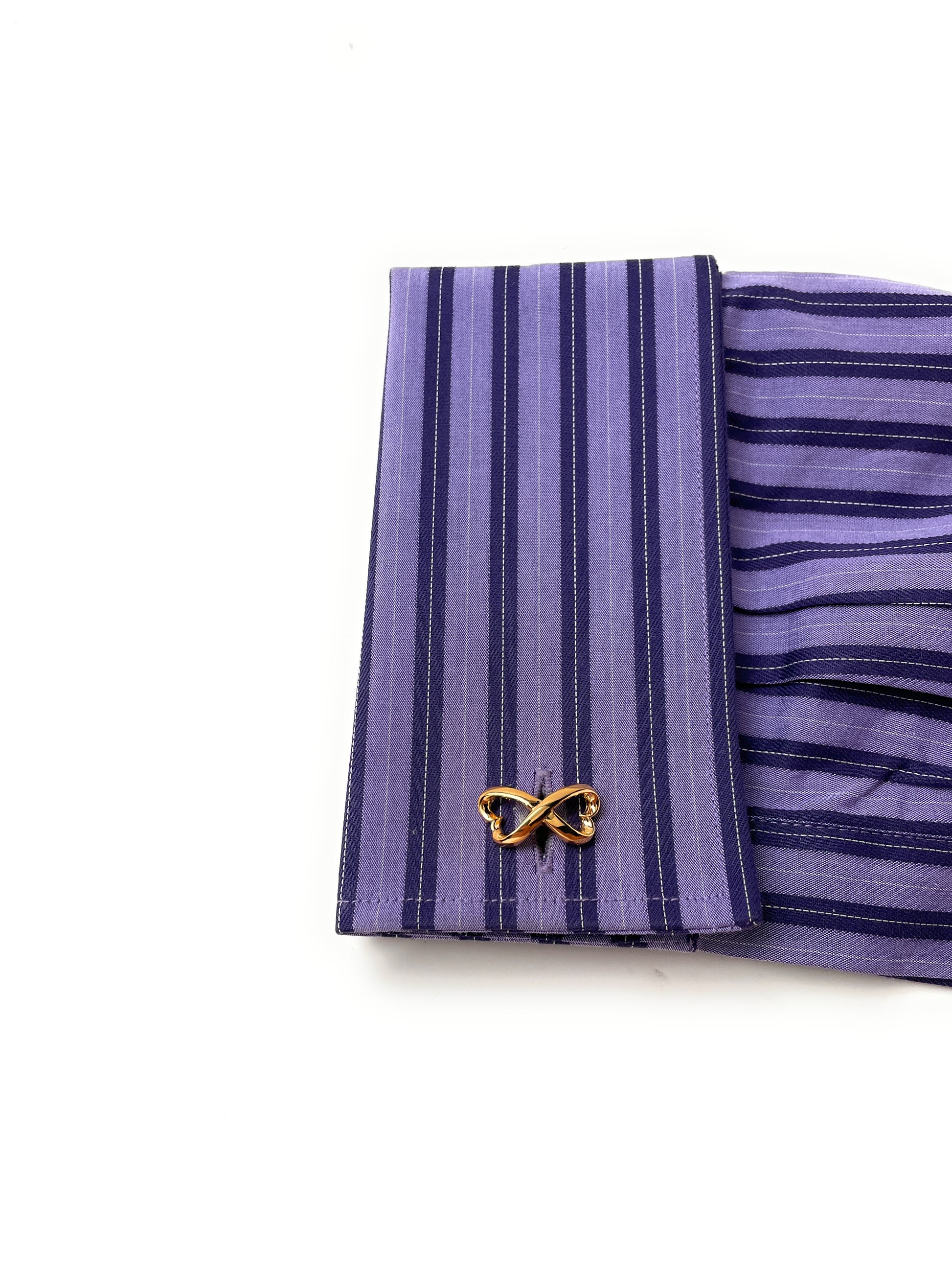 Purple striped fabric with a gold butterfly clip on a white background