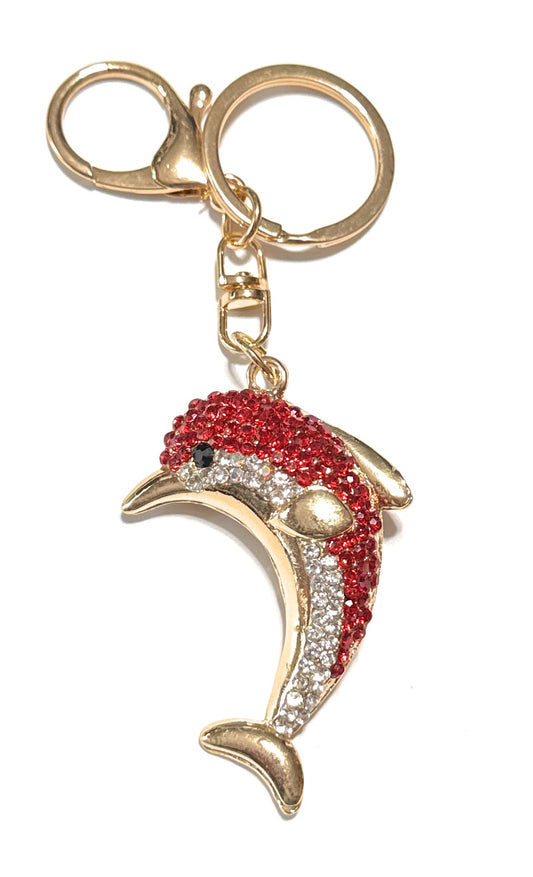 Dolphin-shaped keychain with red and gold design on a white background