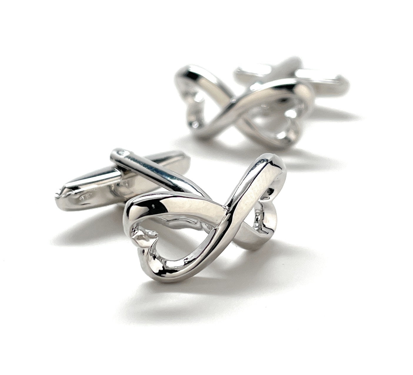Silver knot cufflinks on a white background