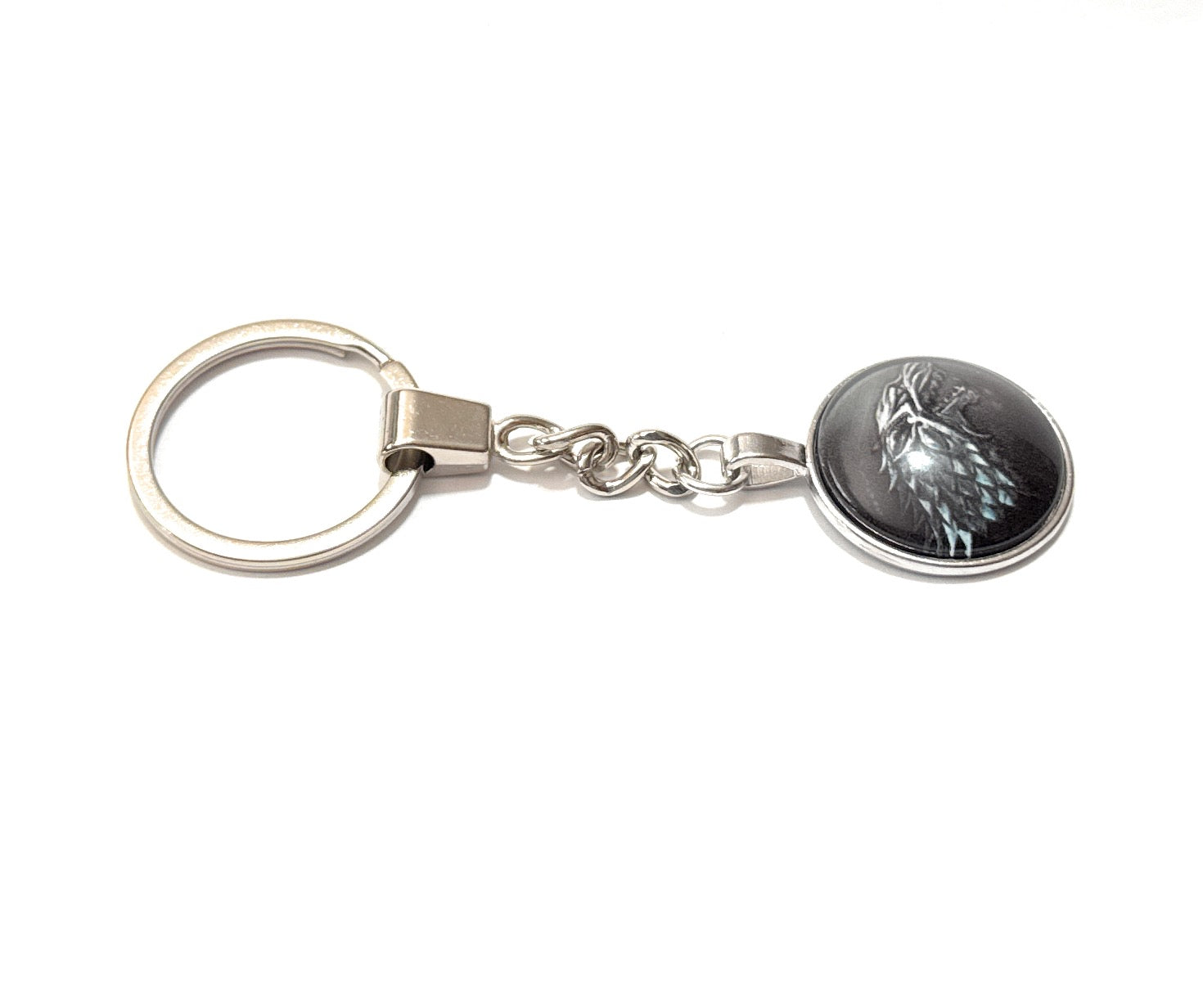 Keychain with a circular emblem featuring a wolf design on a white background