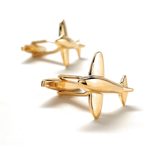 Gold airplane-shaped cufflinks on a white background