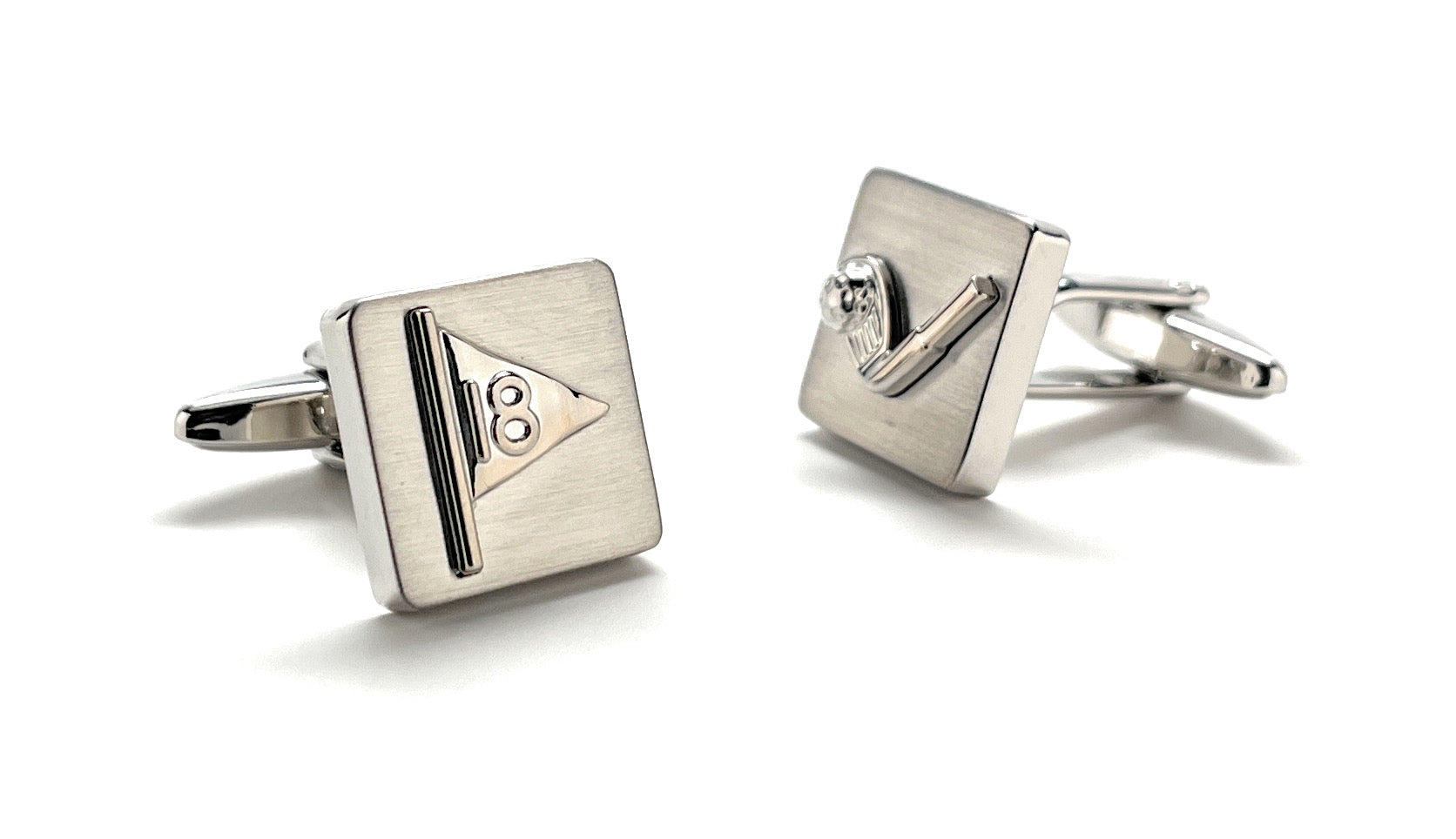 Pair of silver cufflinks with geometric design on a white background