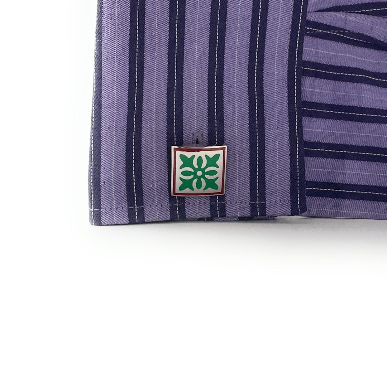 Close-up of a purple striped shirt with a brand logo on a white background