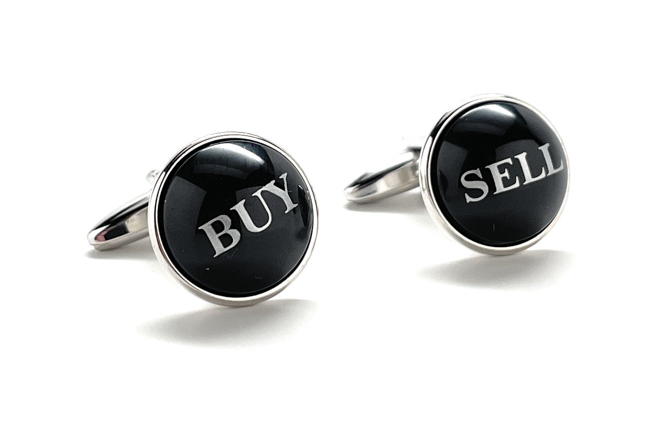 Cufflinks with 'BUY' and 'SELL' text on black stones against a white background