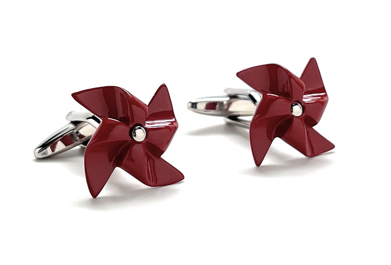 Red pinwheel-shaped cufflinks on a white background