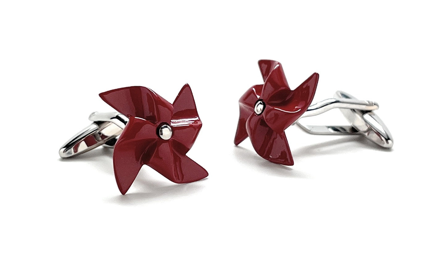 Red pinwheel-shaped cufflinks on a white background