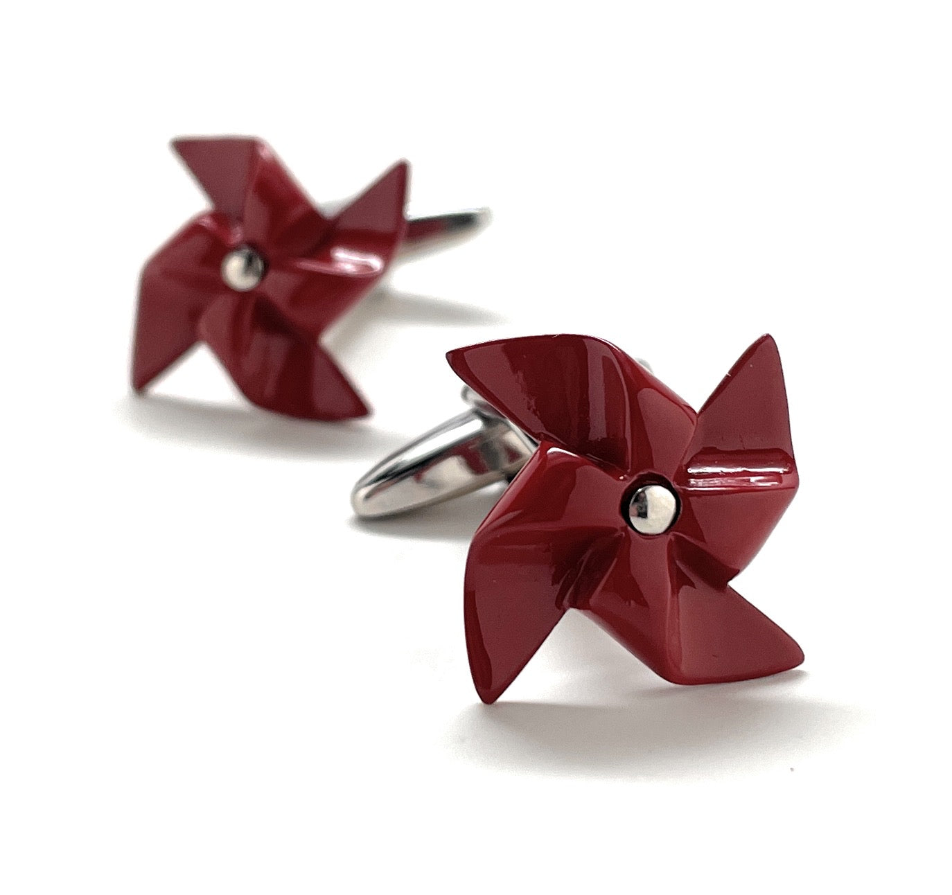 Red pinwheel-shaped cufflinks on a white background