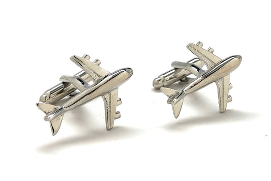 Pair of silver airplane-shaped cufflinks on a white background
