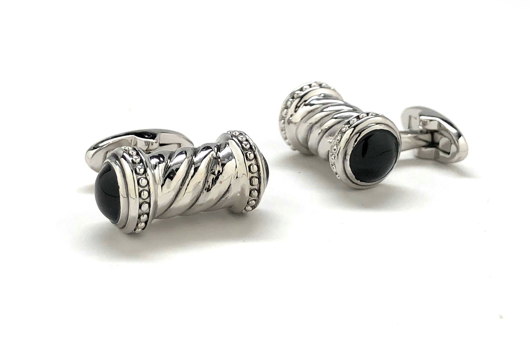 Pair of silver cufflinks with black gemstones on a white background