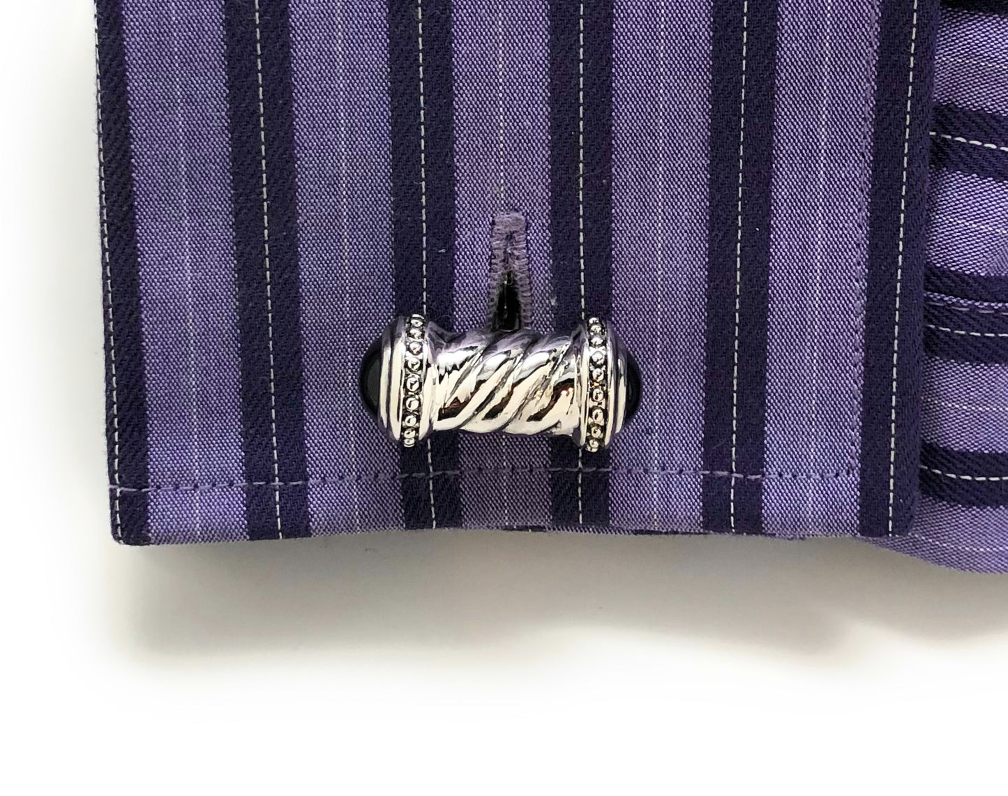 Silver cufflink on a purple striped shirt