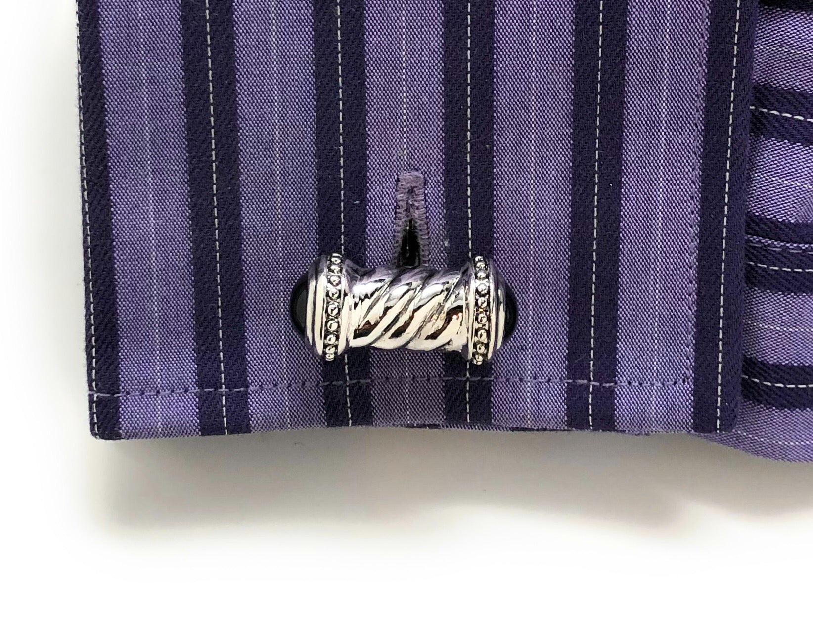 Silver cufflink on a purple striped shirt