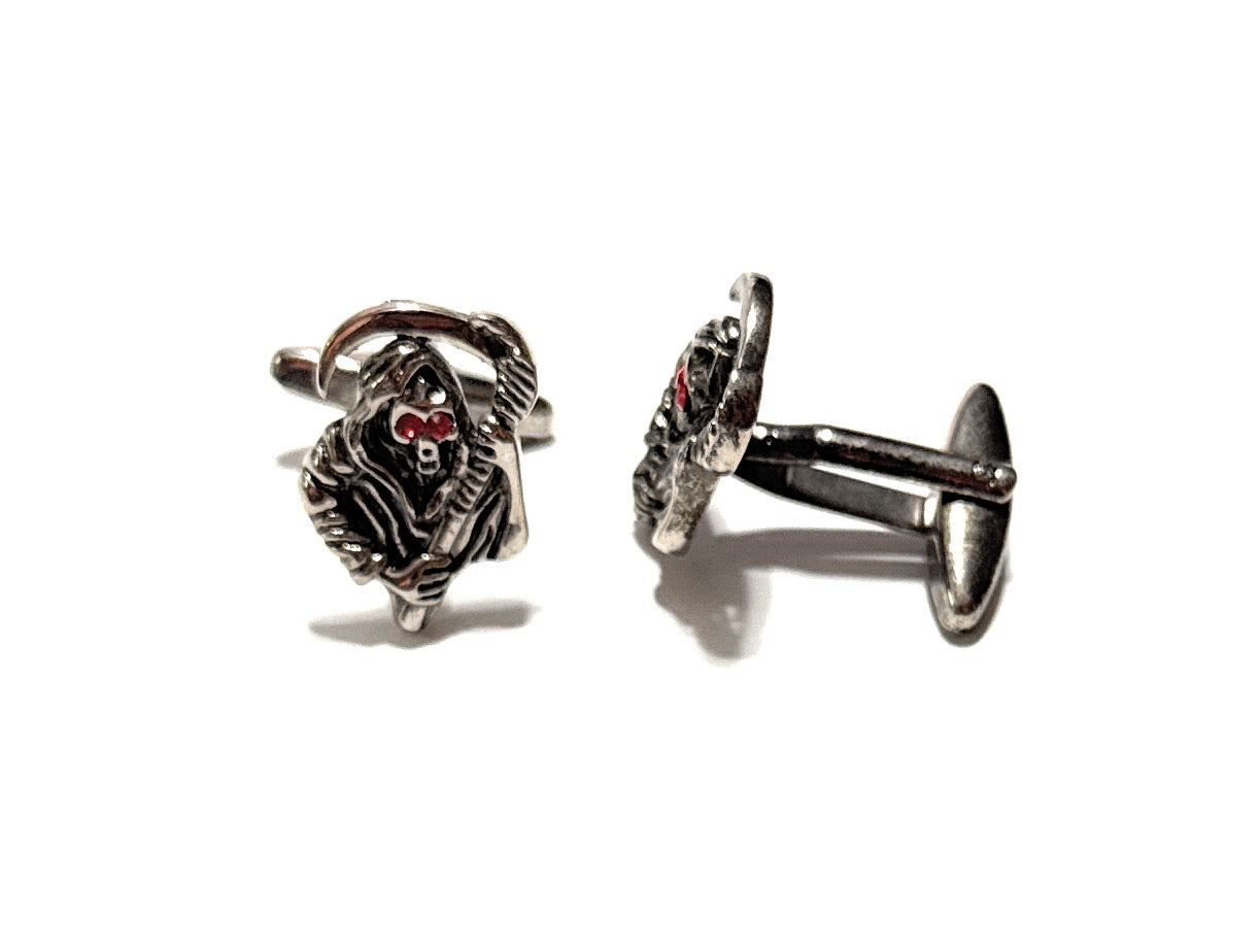 Pair of silver cufflinks with intricate design on a white background