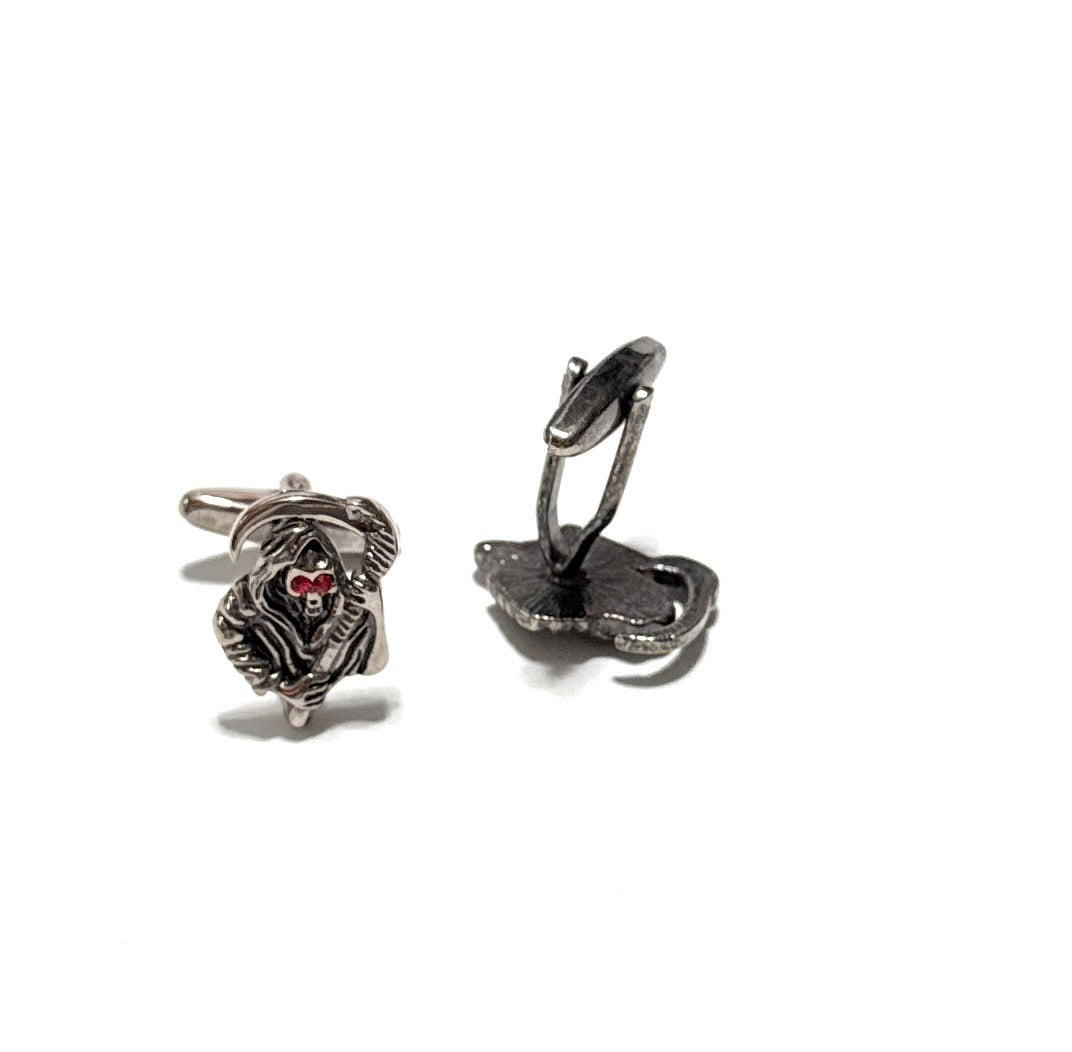 Pair of silver skull-themed earrings on a white background