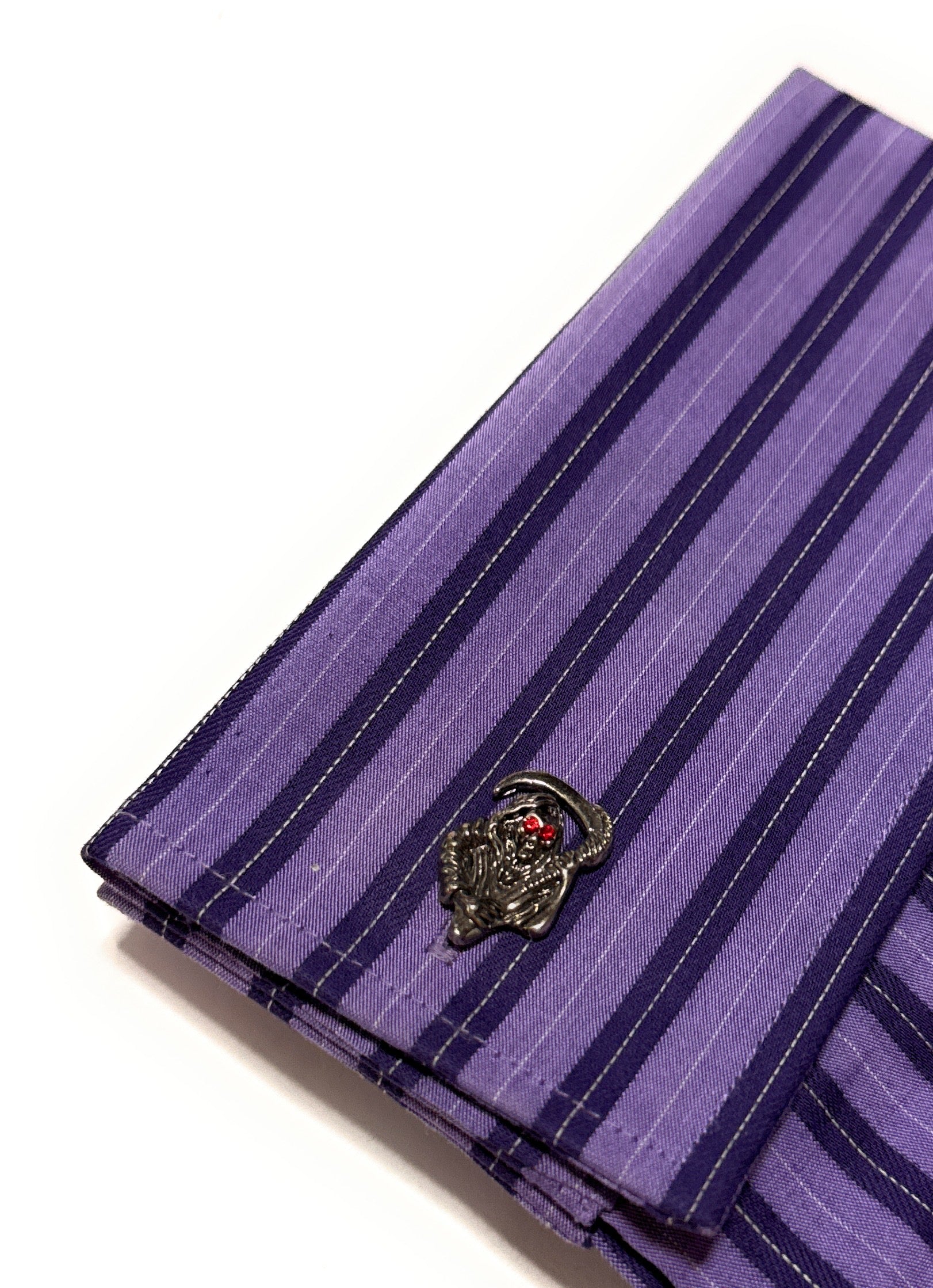 Purple striped pocket square with a decorative clasp on a white background