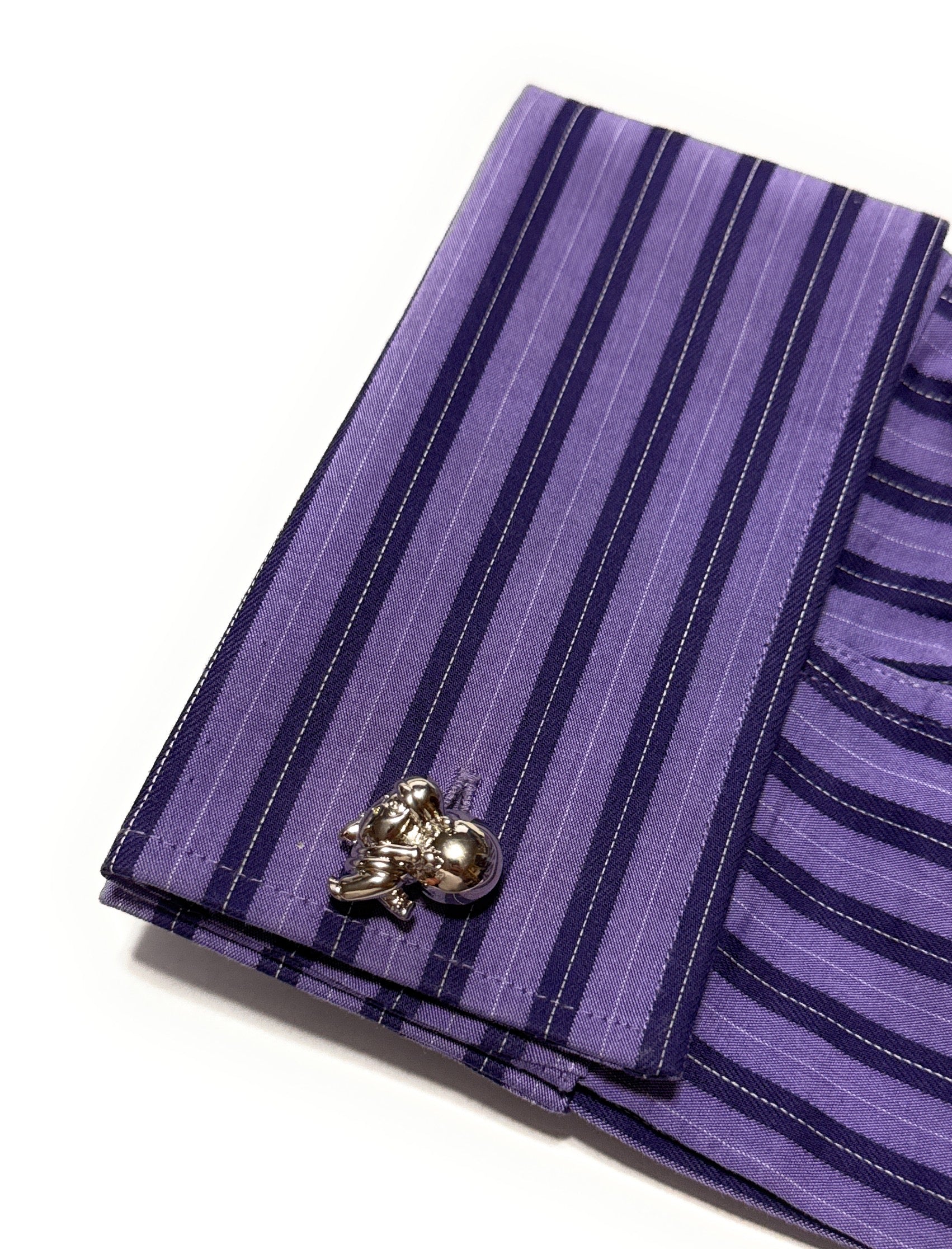 Purple striped pocket square with a decorative clip on a white background