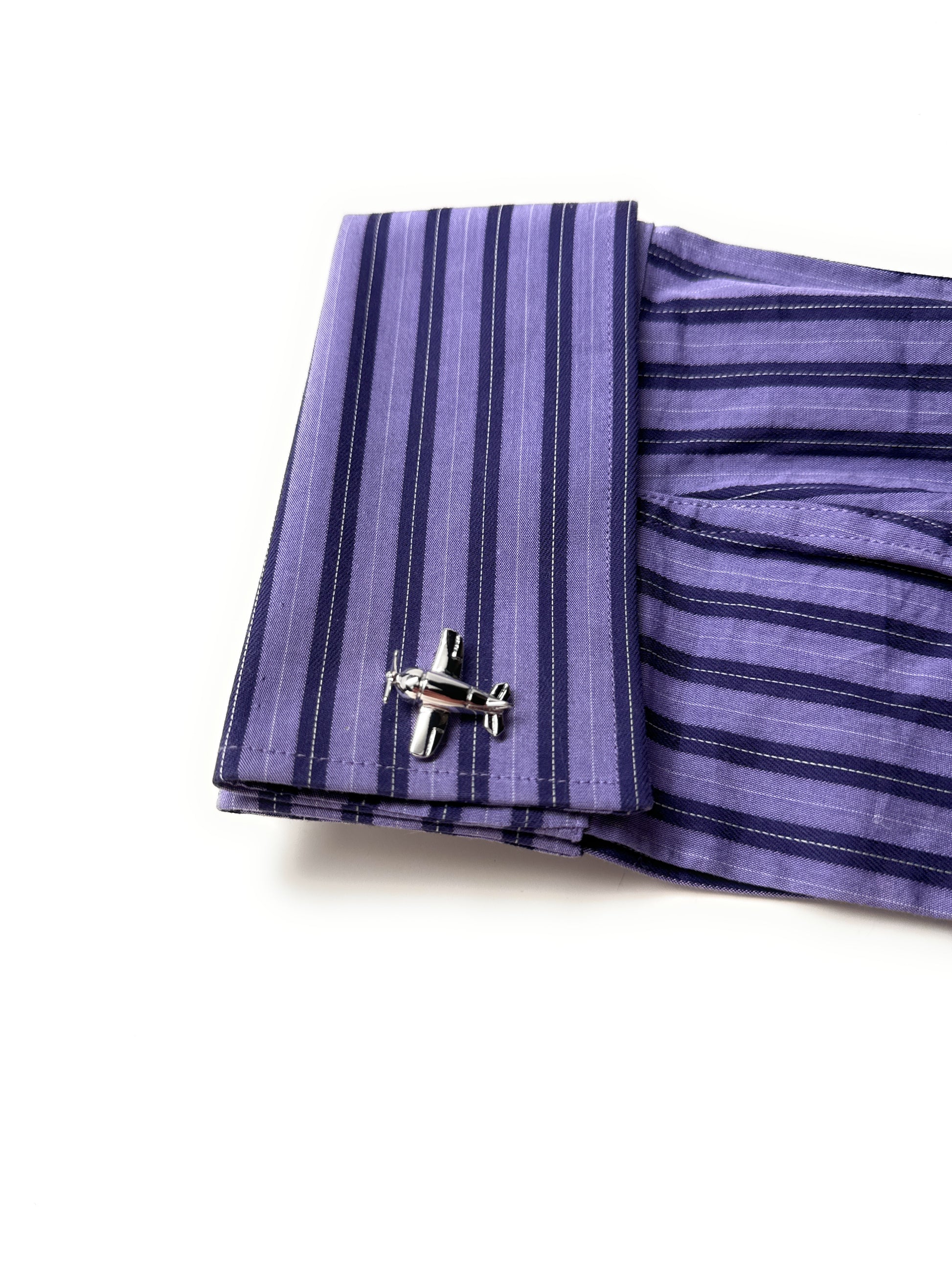 Purple striped fabric with a small airplane-shaped object on a white background
