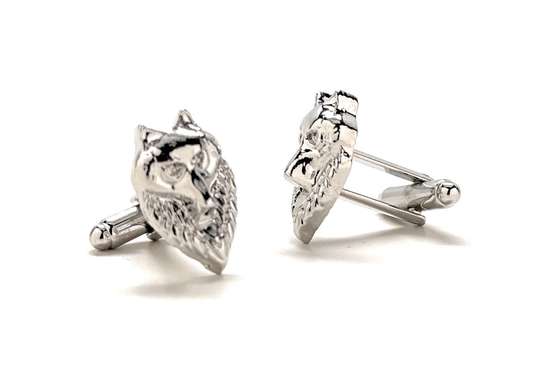 Pair of silver cufflinks with intricate designs on a white background