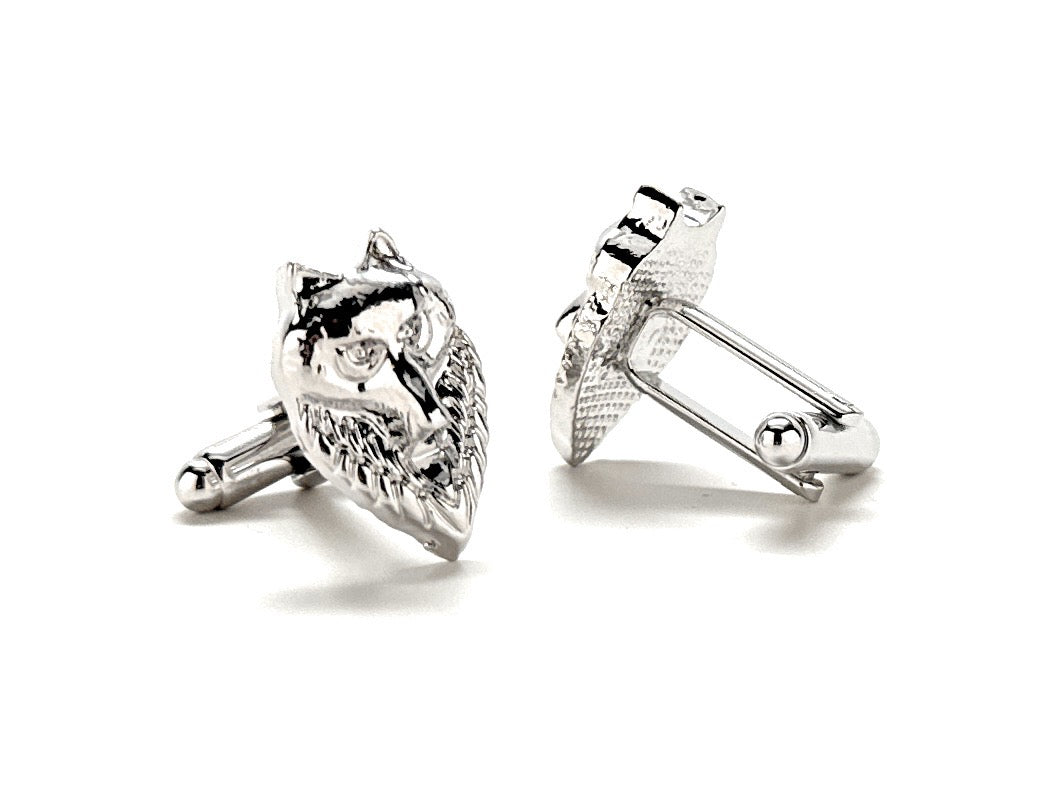 Silver cufflinks with intricate designs on a white background