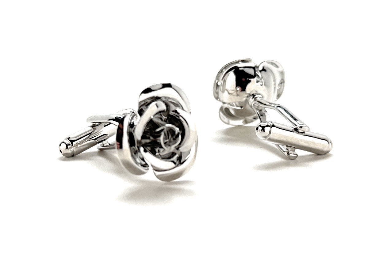 Silver rose-shaped cufflinks on a white background