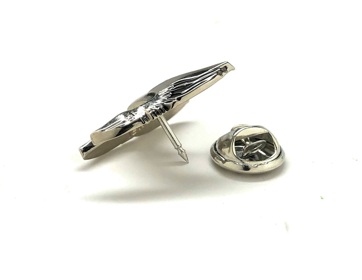 Silver tie pin and lapel pin on a white background