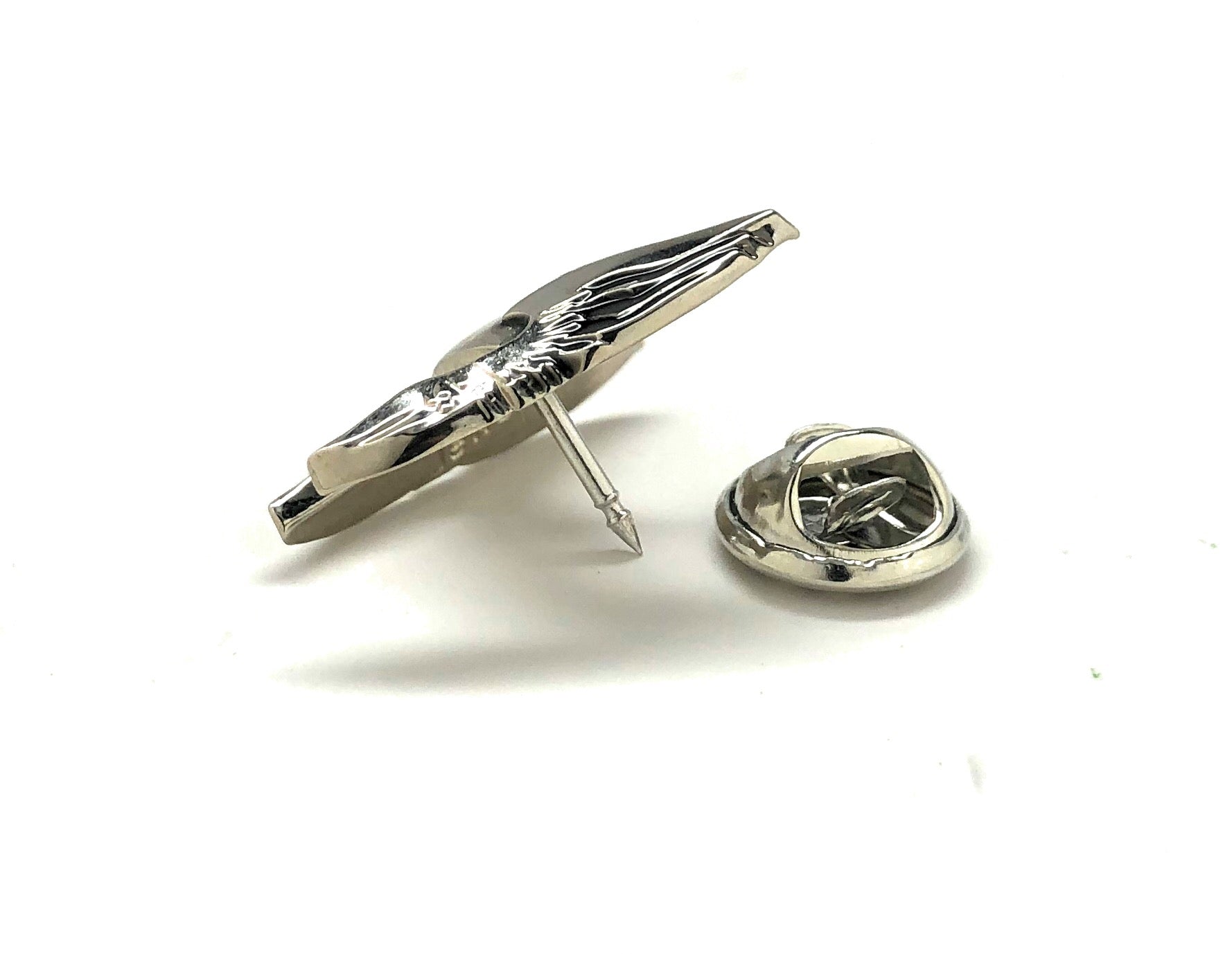 Silver tie pin and lapel pin on a white background
