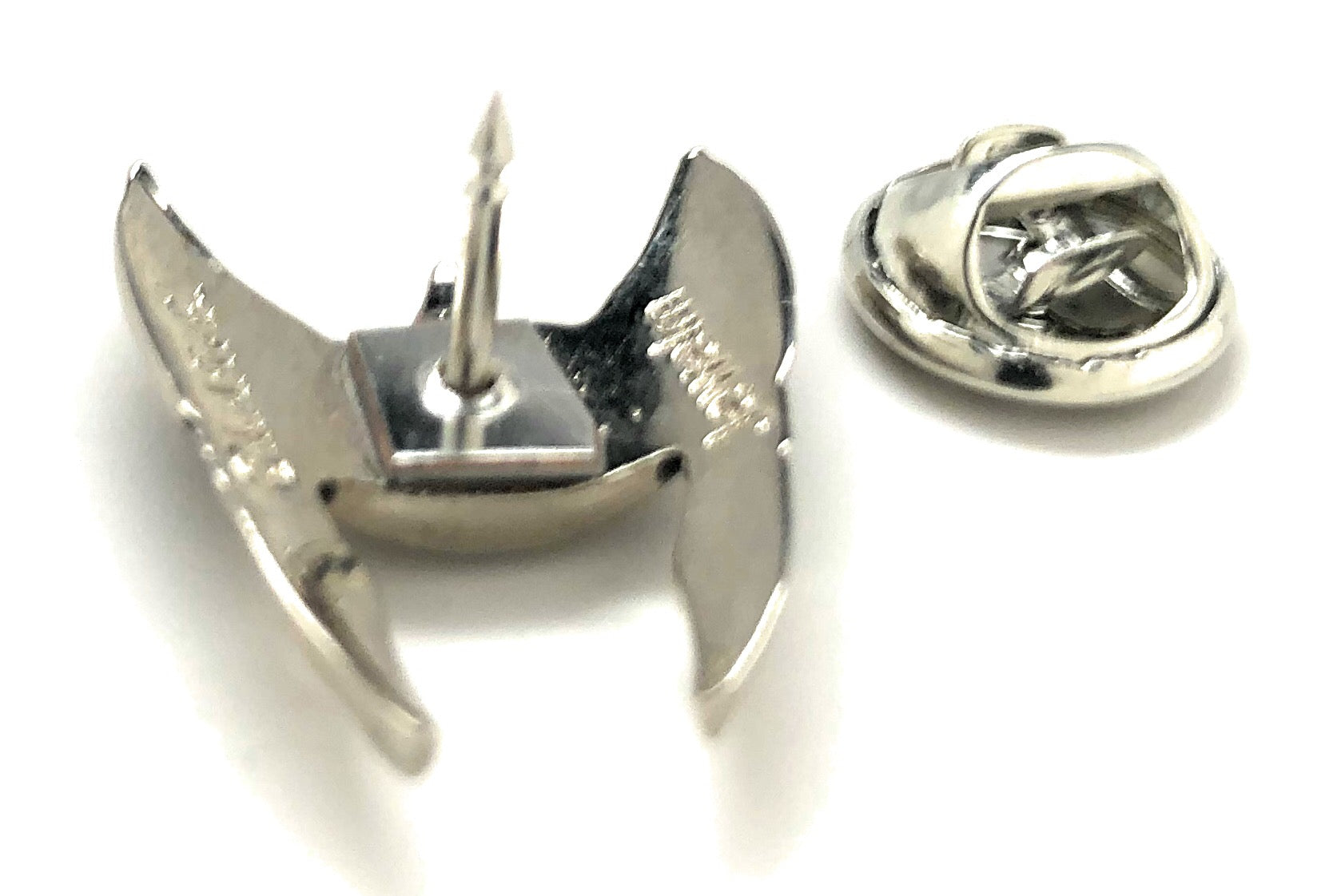 Silver crab-shaped lapel pin on a white background