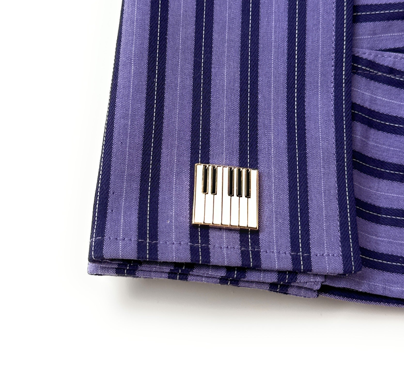 Close-up of a purple striped fabric with a metal tag on a white background