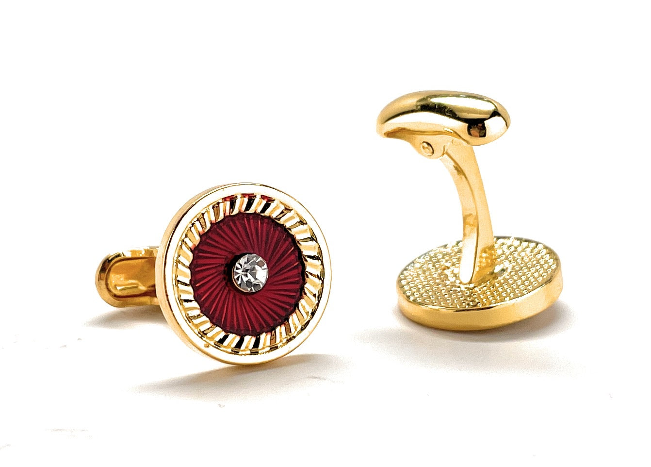 Gold cufflinks with a red circular design and central gemstone on a white background