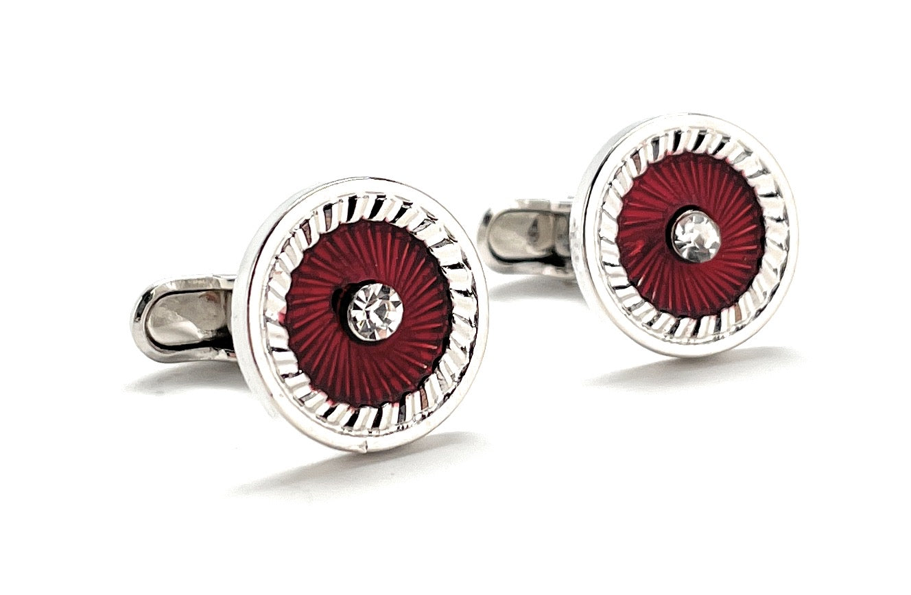 Round cufflinks with red center and silver border on a white background