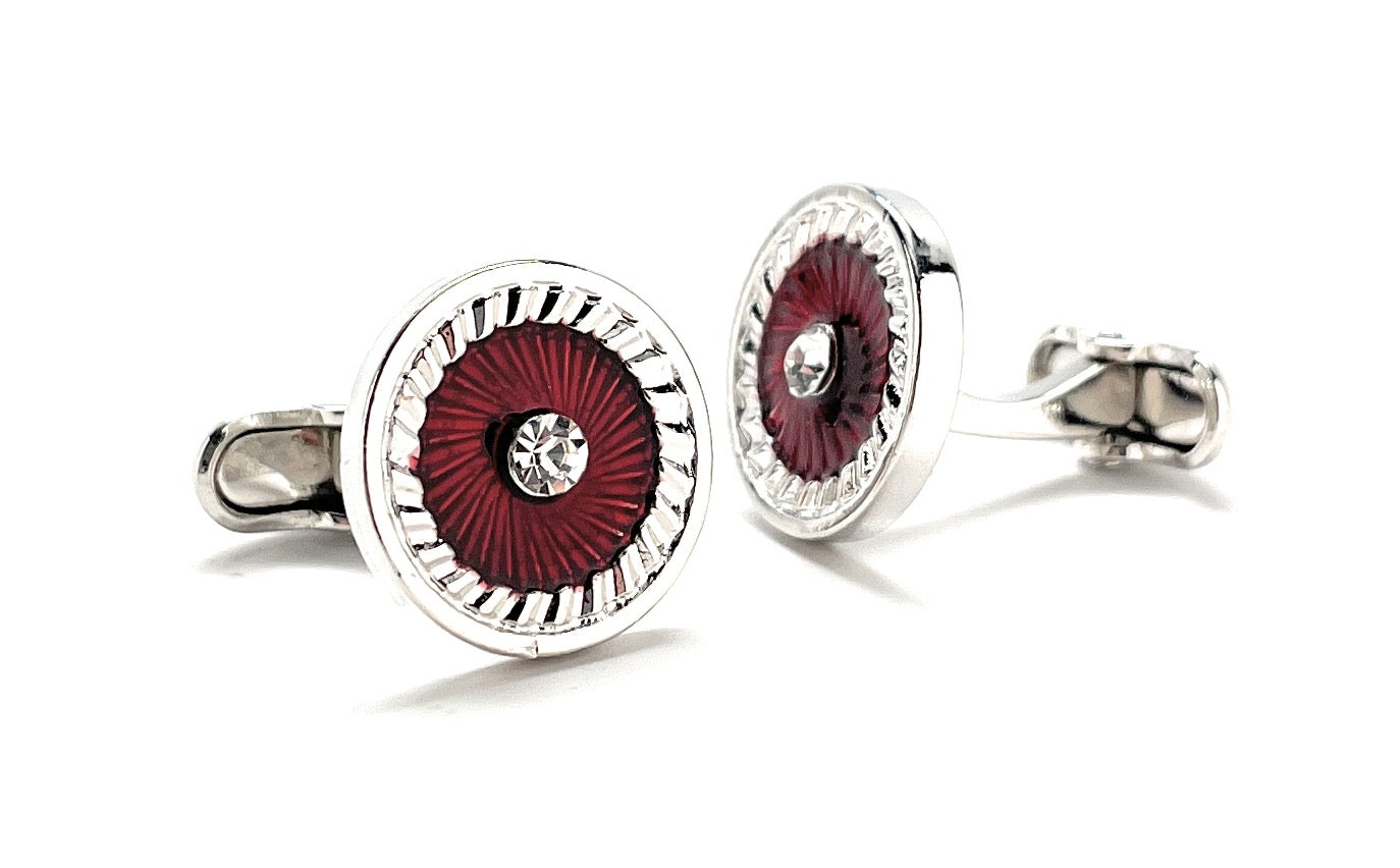 Pair of silver cufflinks with red circular design on a white background