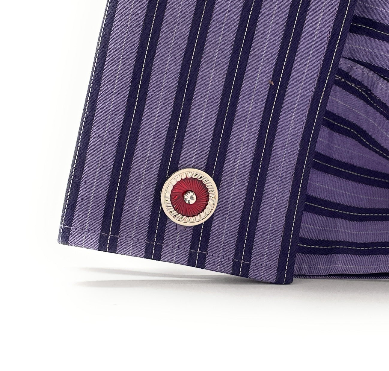 Close-up of a purple striped shirt with a button on a white background