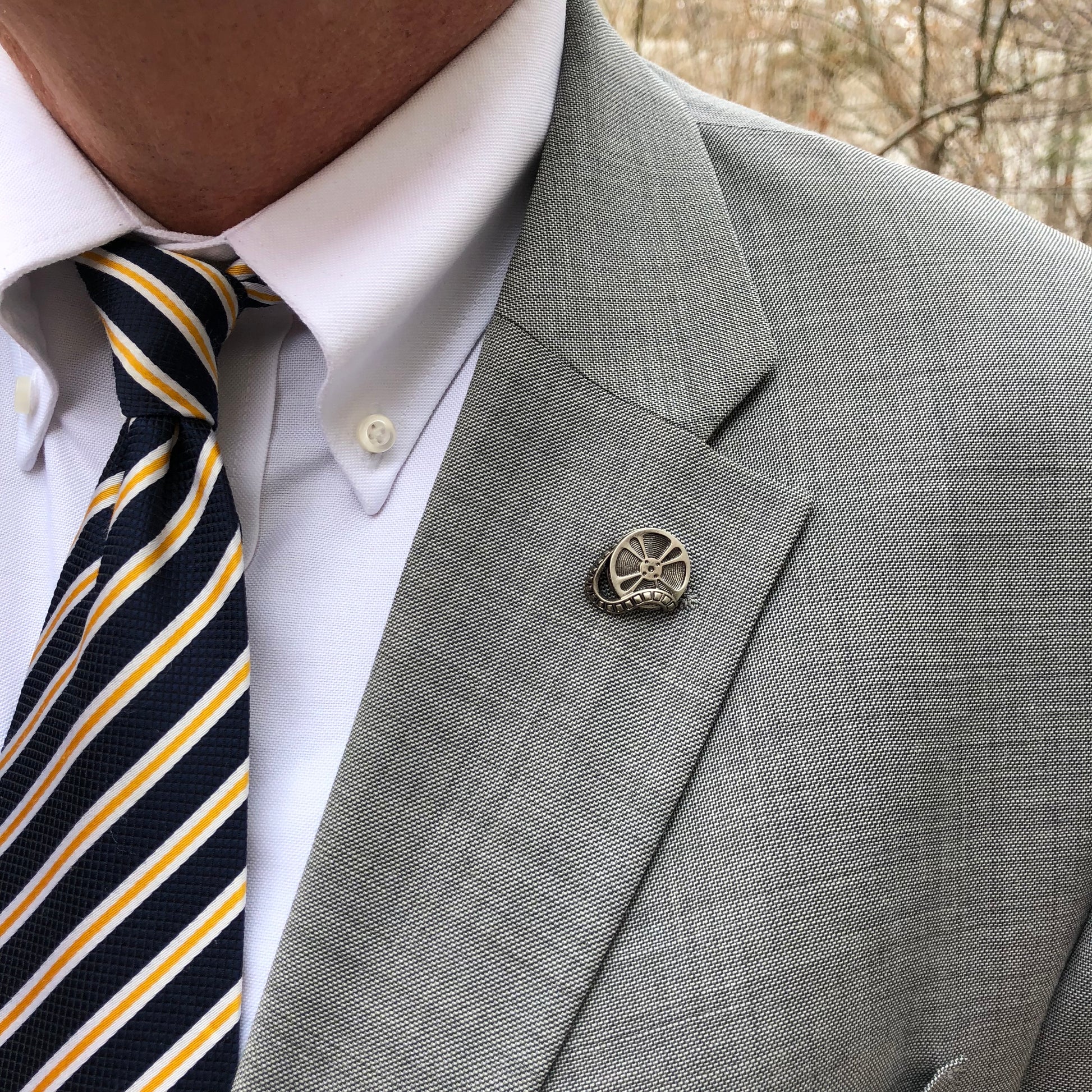 Vintage Movie Reel Lapel Pin – Antique Silver Film Strip Design for Cinema Lovers & Filmmakers