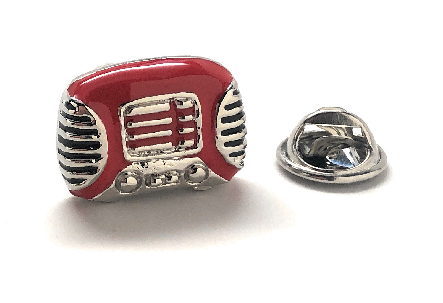 Red and silver microphone-shaped lapel pin on a white background