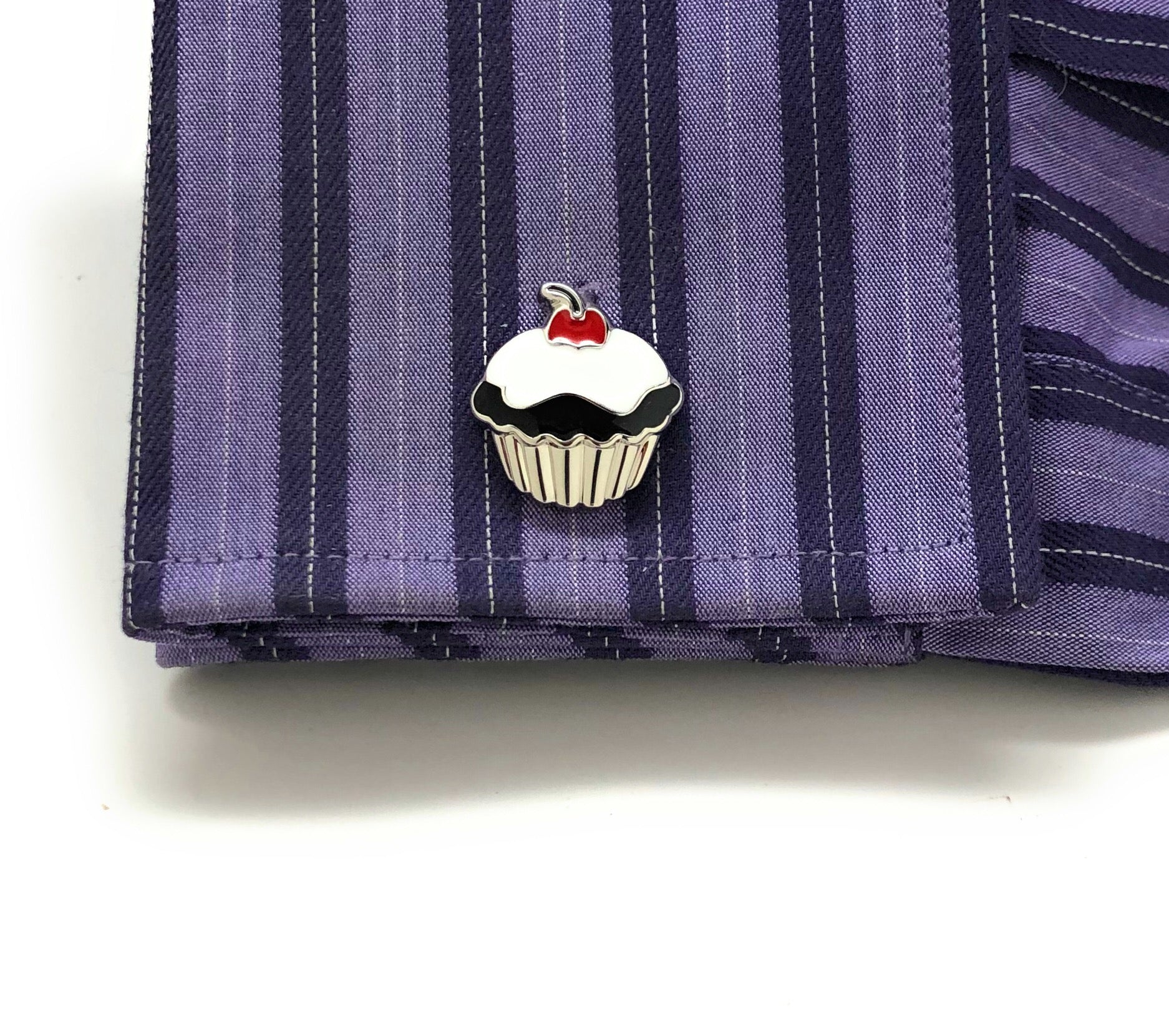 Cupcake-shaped pin on a striped shirt