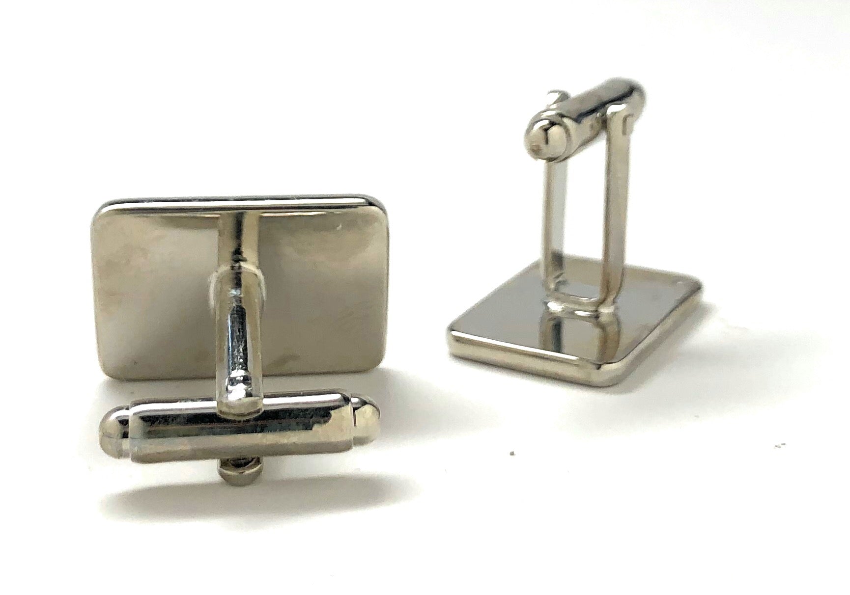 Pair of silver cufflinks on a white background