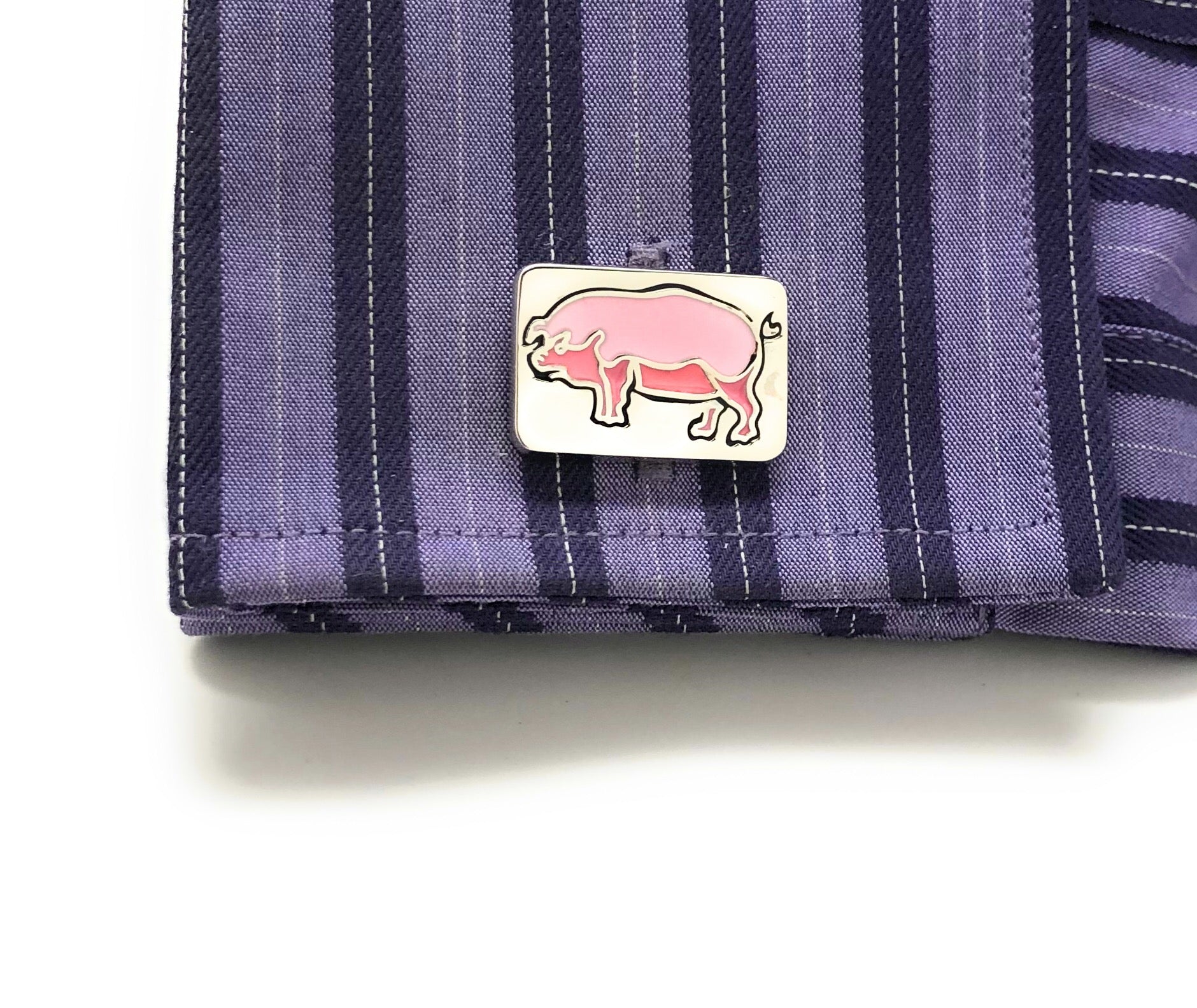 Purple striped fabric with a pink hippo emblem on a white background