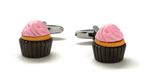 Cupcake-shaped cufflinks with pink frosting and black bases on a white background