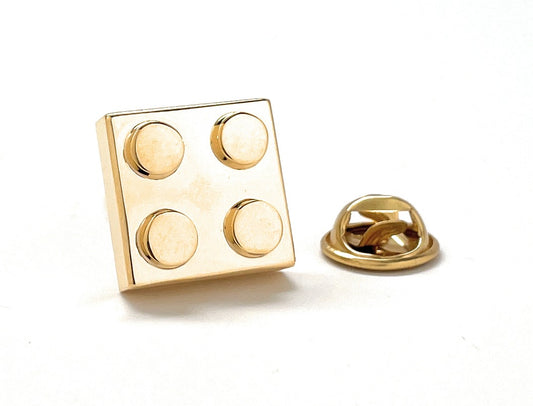 Gold square pin with circular designs on a white background
