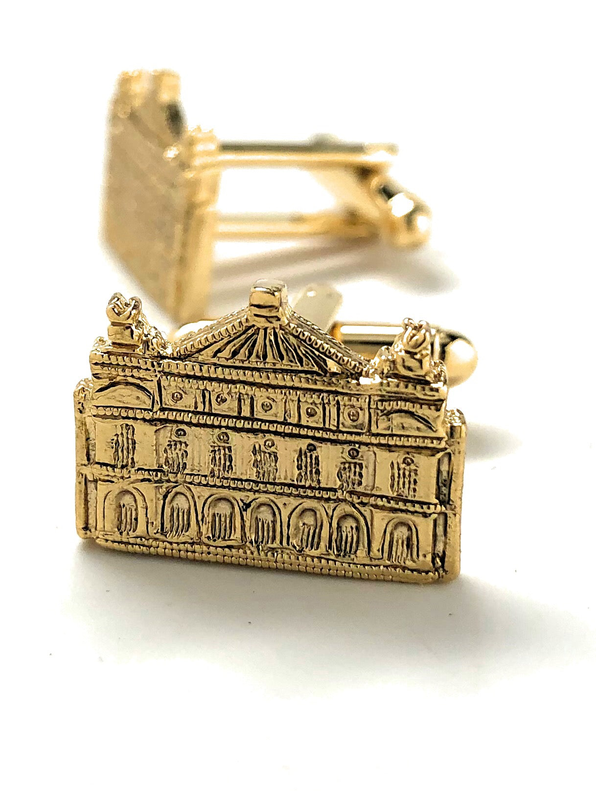 Gold architectural cufflinks on a white background