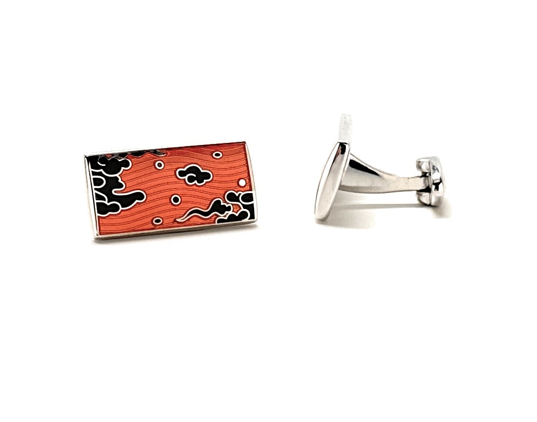 Cufflinks with a red and black abstract design on a white background
