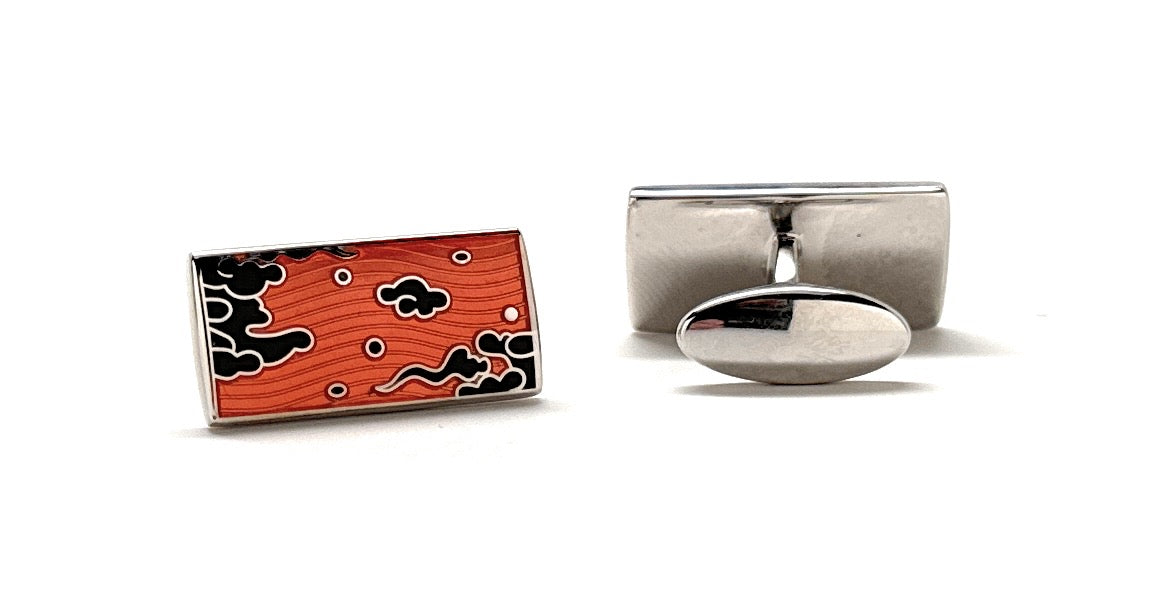 Cufflinks with a red and black abstract design on a white background